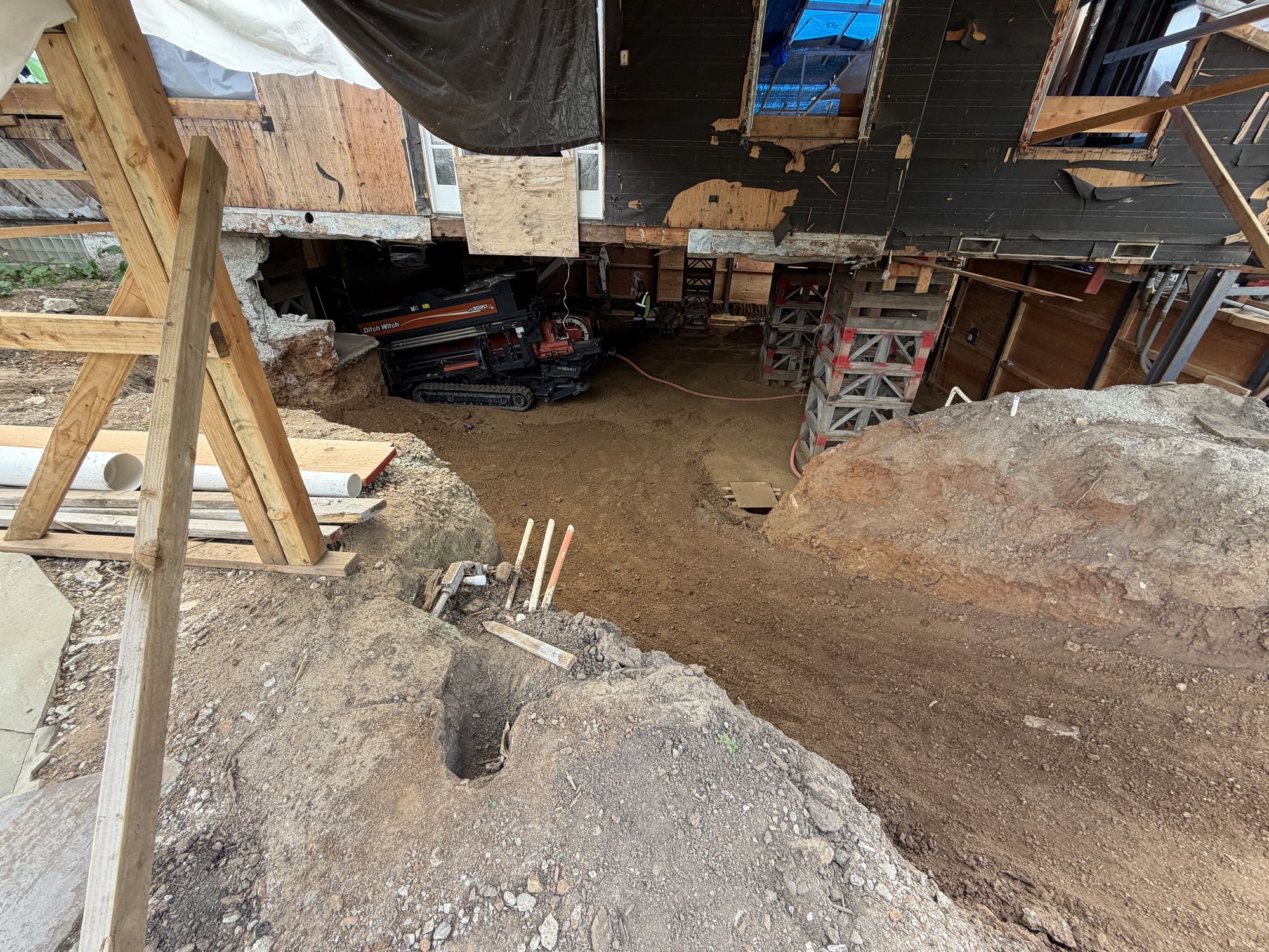 Drill entry pit dug in the basement corner with the rig behind