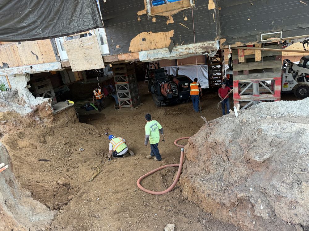 Apex crew in the excavated basement under a lifted house in Los Gatos