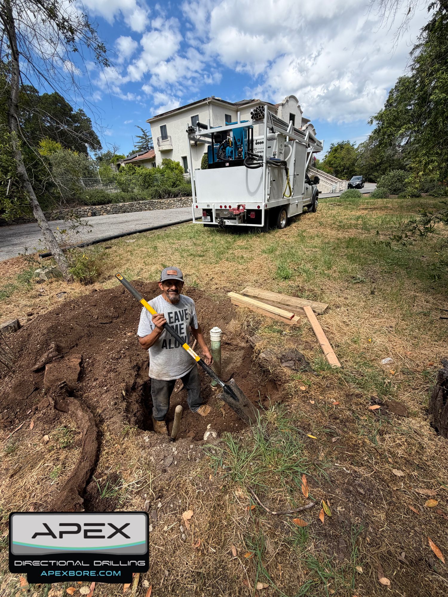Apex owner David Lara standing in a pothole with a shovel