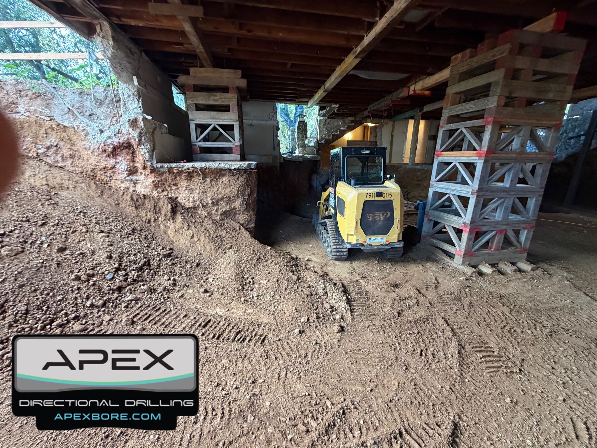 Skid steer cleaning up the basement after drilling