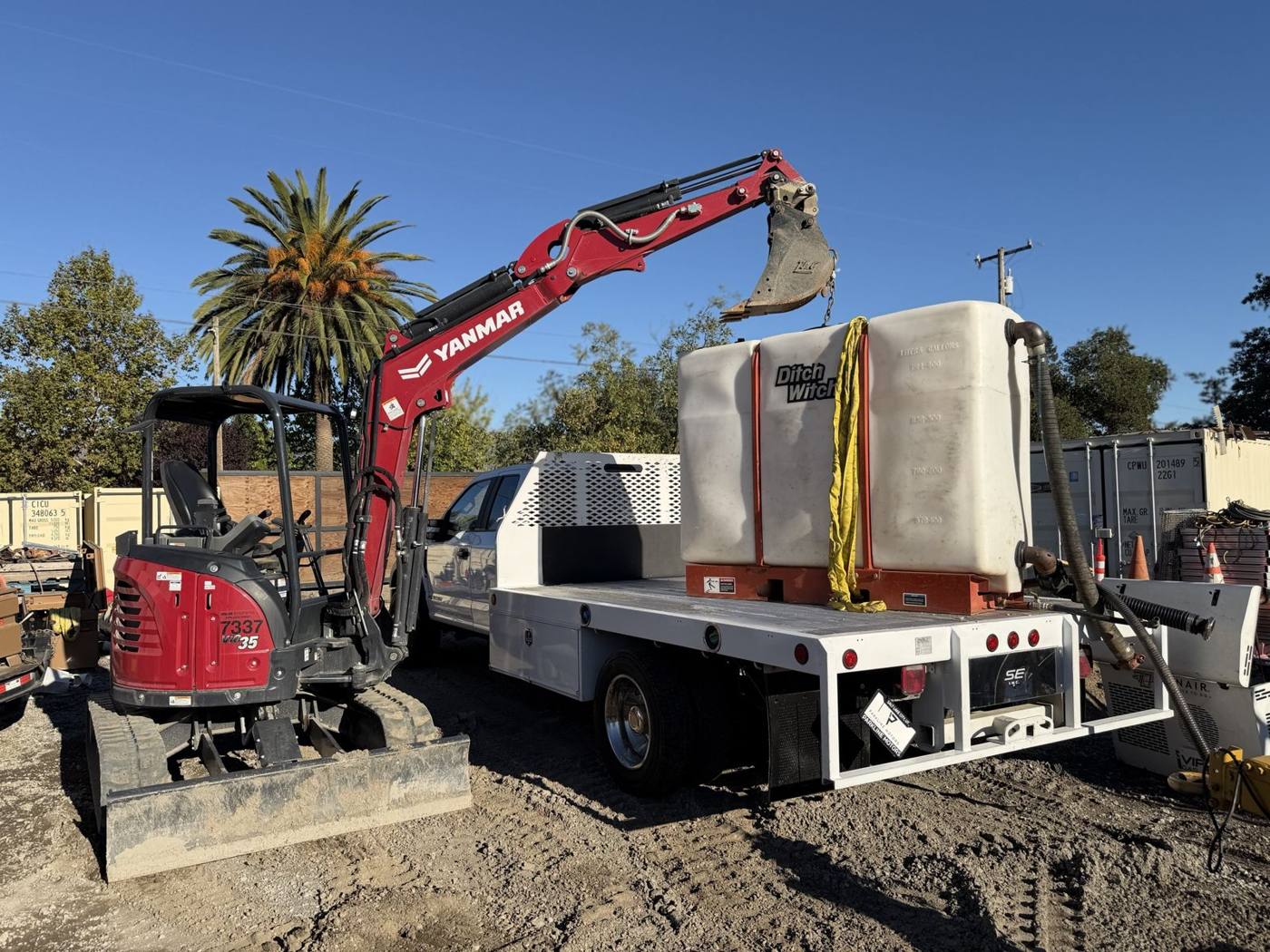 Yanmar ViO35 mini excavator lifting a tank onto a flatbed truck