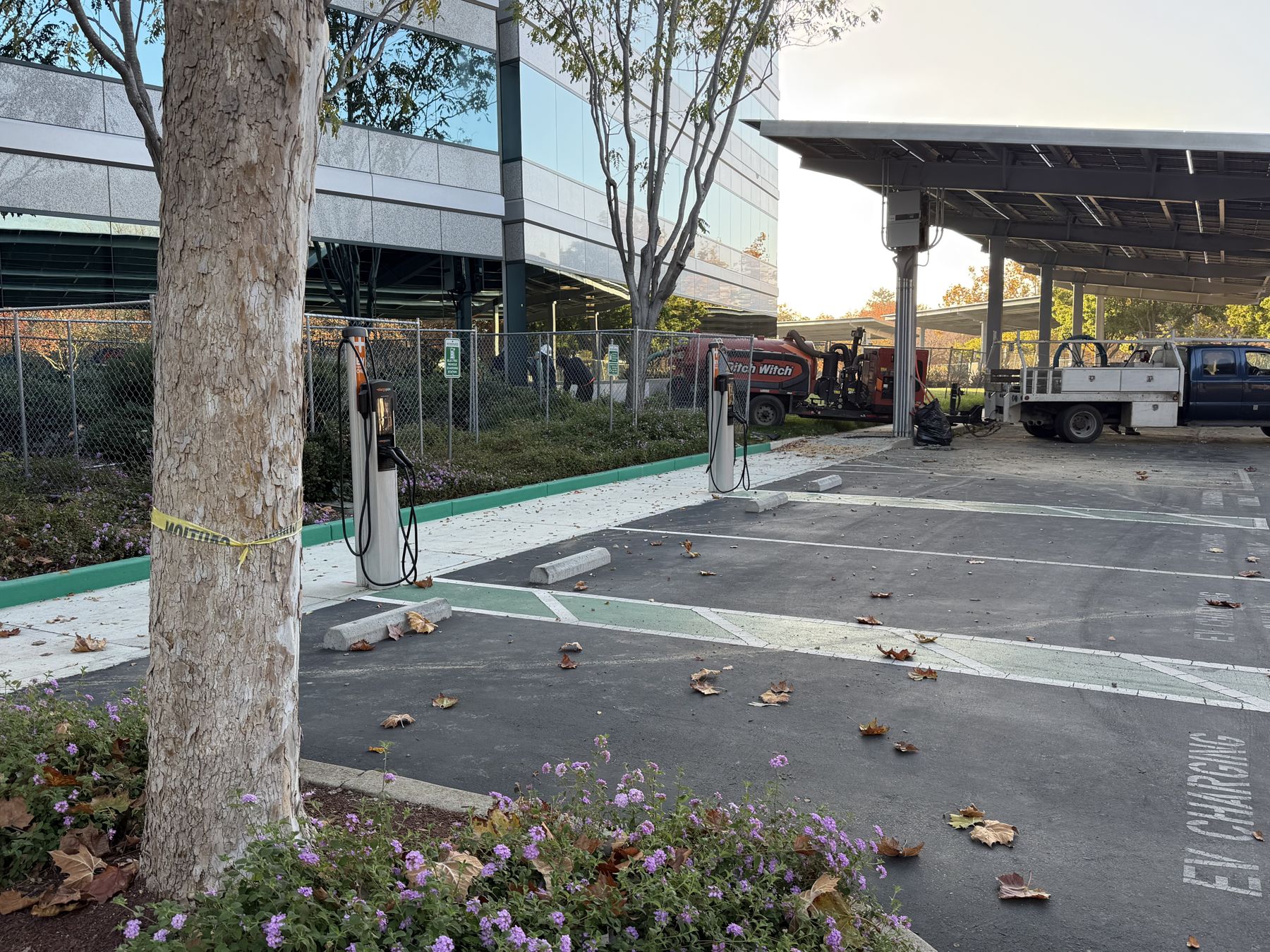 Row of EV chargers along a parking lot under construction
