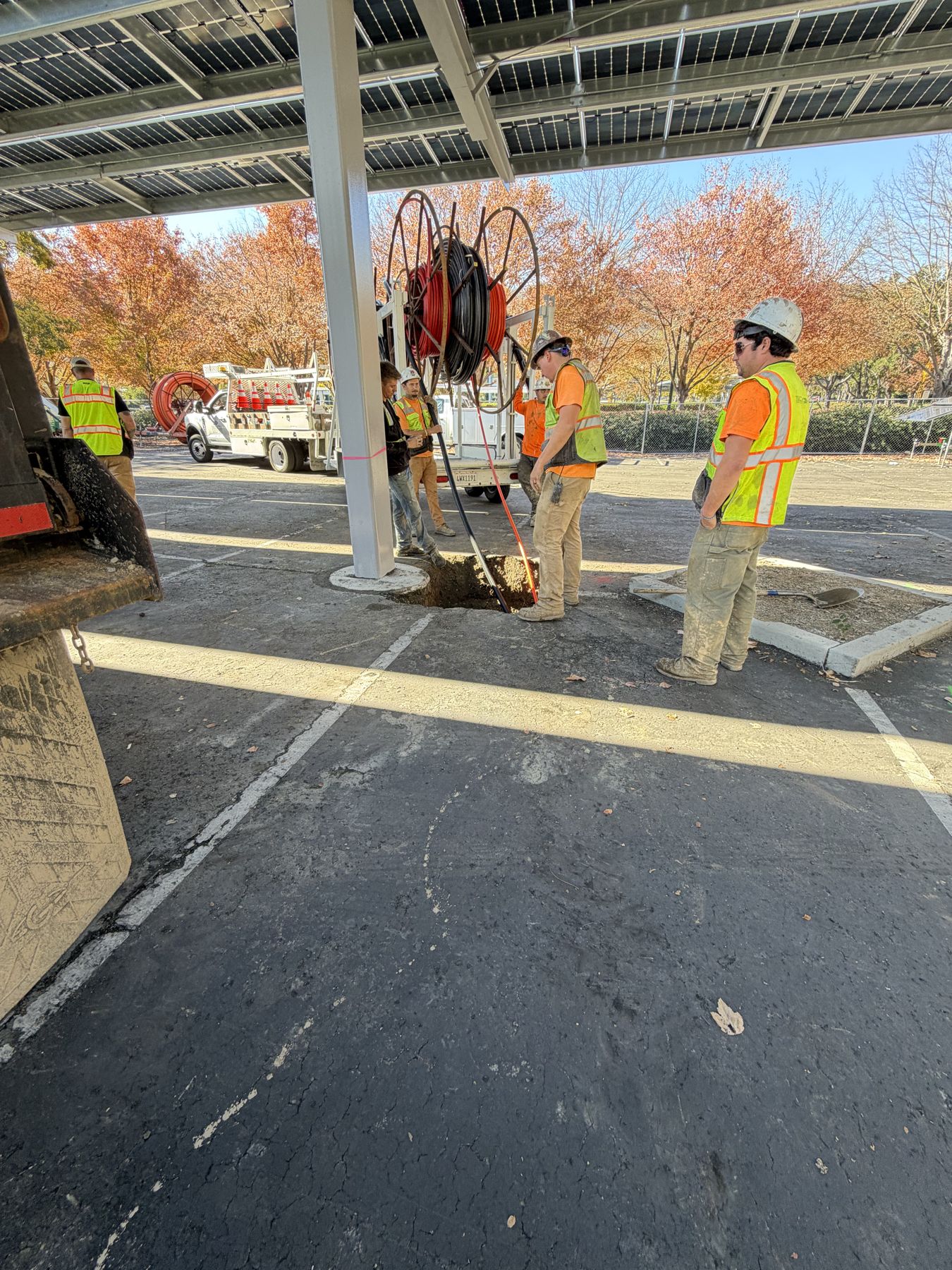 Crew with a reel of HDPE conduit under the canopy