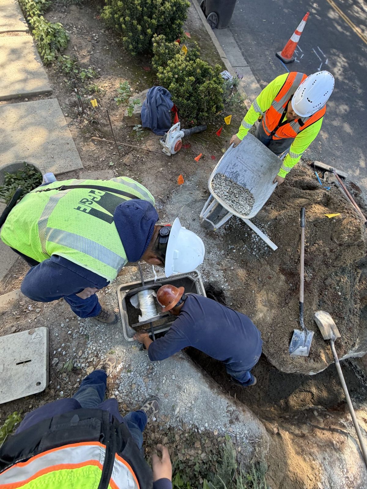Crew setting a utility box in a landscaped yard