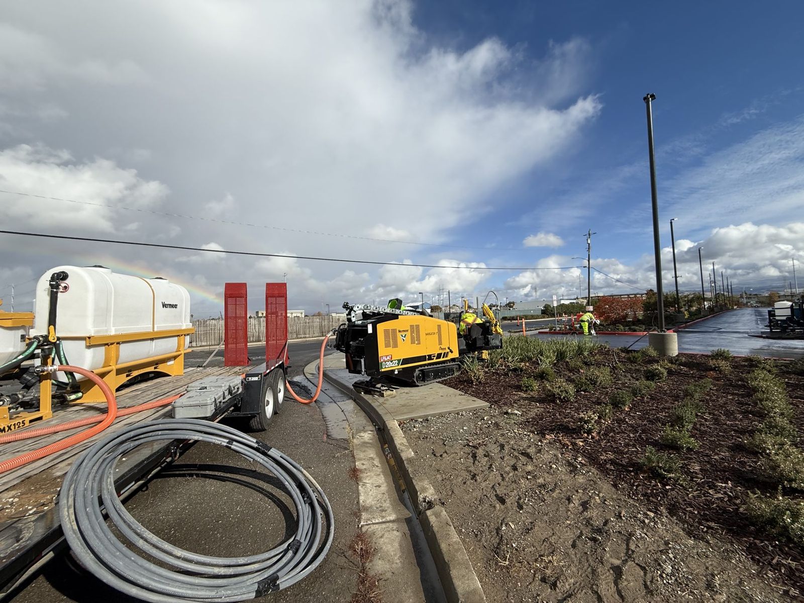 Compact drill boring across a planter strip with conduit staged