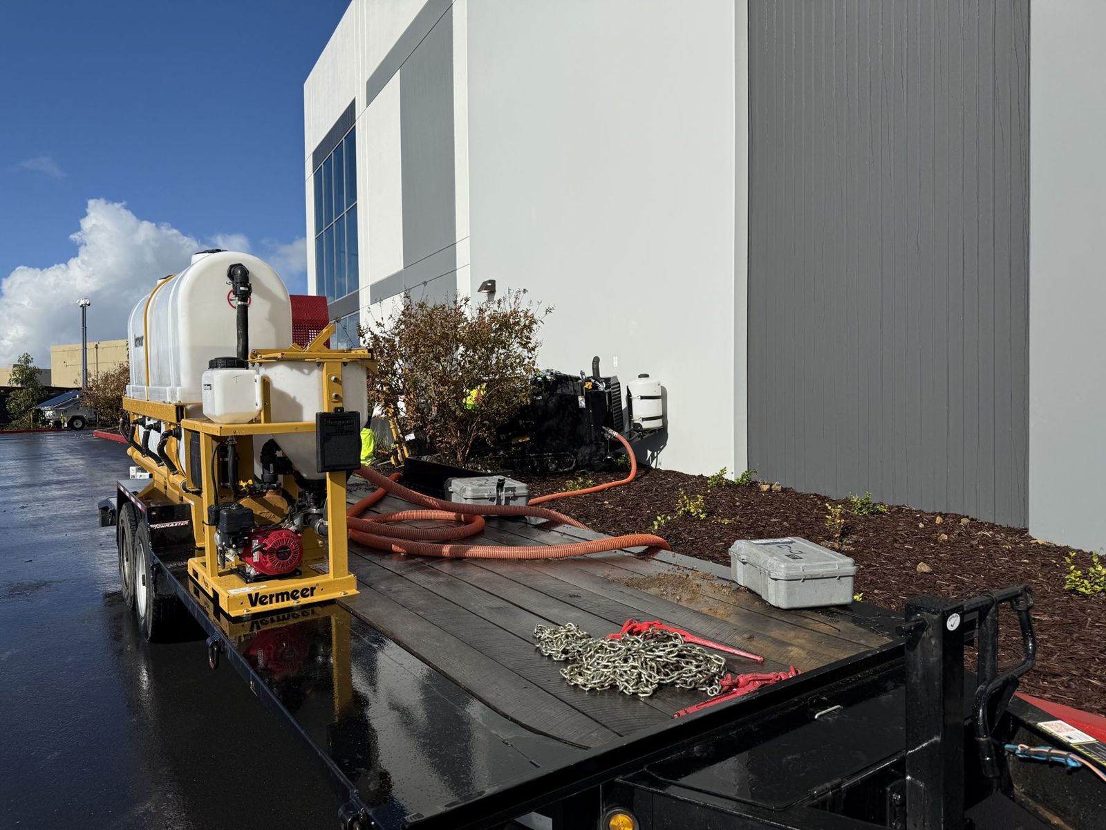 D8x12 drill and fluid trailer set up beside a commercial building