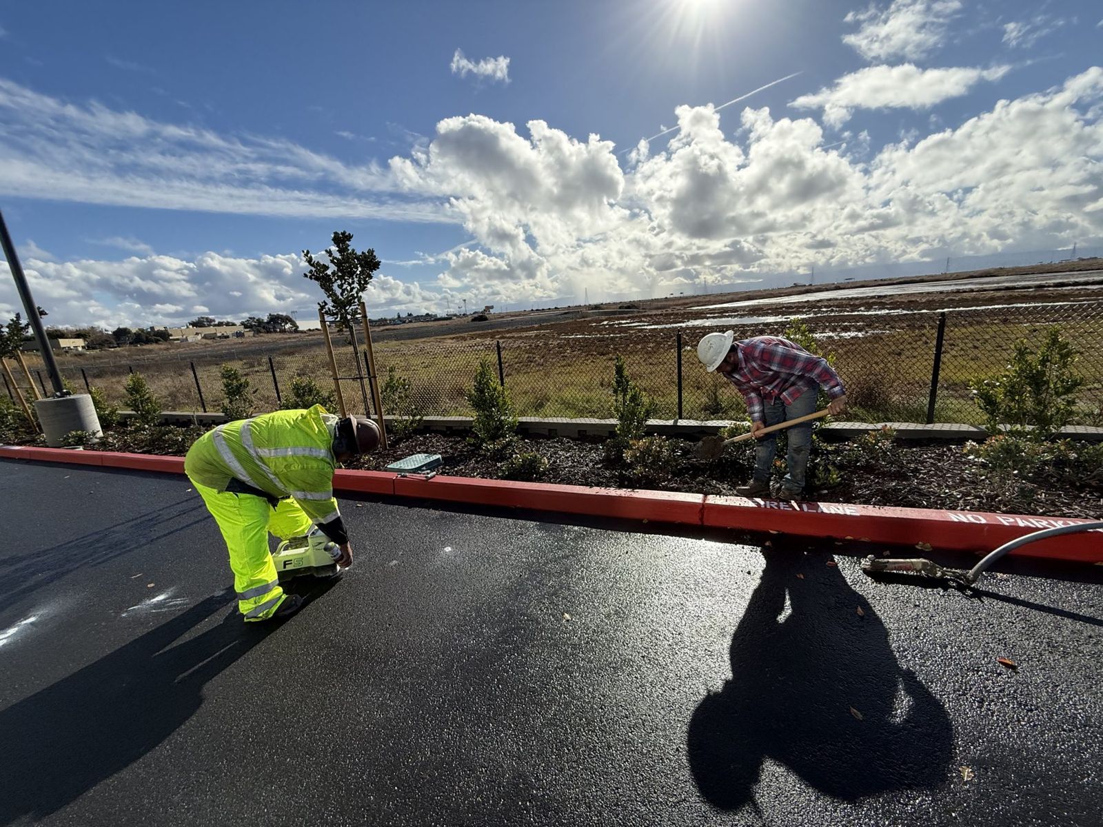 Crew tracking the drill head along a red curb
